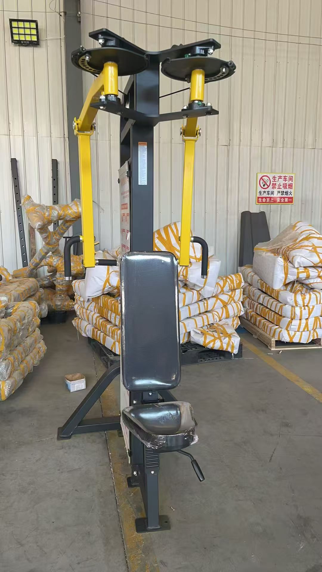 Seated shoulder press machine in yellow and black